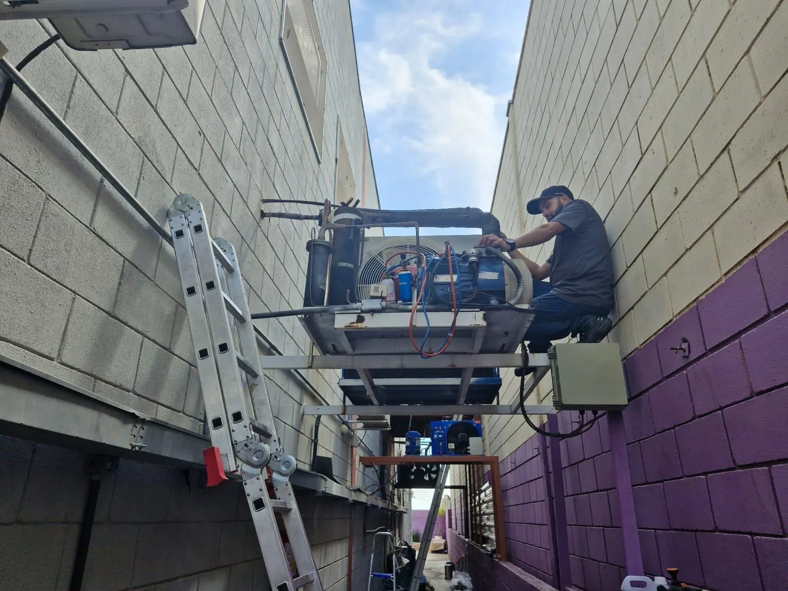 Técnico da Vittecniq fazendo manutenção em unidade condensadora de câmara fria em altura